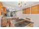 Kitchen featuring stone countertops, wooden cabinets, stainless steel appliances, and a rustic dining table at 7624 S Cove Cir, Centennial, CO 80122