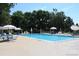 Community pool with ample seating and umbrellas, surrounded by mature trees at 7624 S Cove Cir, Centennial, CO 80122