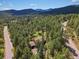 Stunning aerial view of a secluded home amidst a dense forest and winding roads at 8422 S Ault Ln, Morrison, CO 80465