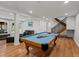 Spacious basement rec room featuring a pool table, staircase and access to additional living space at 8422 S Ault Ln, Morrison, CO 80465