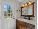 Bathroom features a vanity with a wooden cabinet, marble countertop, and a window to a deck at 8422 S Ault Ln, Morrison, CO 80465