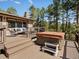 Wooden deck with a hot tub and seating area nestled among tall trees at 8422 S Ault Ln, Morrison, CO 80465