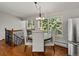 Bright dining area with hardwood floors, modern chandelier, and large windows offering serene wooded views at 8422 S Ault Ln, Morrison, CO 80465
