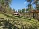Exterior of the house, surrounded by lush greenery and featuring a charming treehouse at 8422 S Ault Ln, Morrison, CO 80465