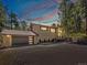 Charming home exterior features a modern garage door, neutral paint, and a wooded lot at 8422 S Ault Ln, Morrison, CO 80465