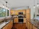 Open-concept kitchen featuring wood cabinets, granite countertops, stainless steel appliances, and recessed lighting at 8422 S Ault Ln, Morrison, CO 80465