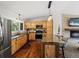 Stylish kitchen featuring wood cabinets, granite countertops, stainless steel appliances, and a large island with bar seating at 8422 S Ault Ln, Morrison, CO 80465