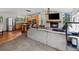 Cozy living area featuring a stone fireplace, wooden mantle, and an open view into the modern kitchen at 8422 S Ault Ln, Morrison, CO 80465