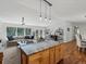 Open-concept living space with kitchen island, dining area, plush sofa, and views of the surrounding nature at 8422 S Ault Ln, Morrison, CO 80465