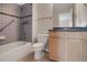 Bathroom with tile shower, tub, and vanity featuring blue countertop and wood cabinets at 13950 E Chenango Dr, Aurora, CO 80015