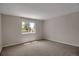 Bedroom with neutral carpet and a window that offers views of neighborhood foliage at 13950 E Chenango Dr, Aurora, CO 80015