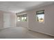 Bedroom featuring carpet, neutral walls, and windows overlooking the neighborhood at 13950 E Chenango Dr, Aurora, CO 80015