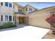 Front exterior showcasing stone accents, a large garage door, and manicured landscaping at 13950 E Chenango Dr, Aurora, CO 80015