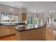 Spacious kitchen showcasing an island, plentiful natural light, and wood flooring at 13950 E Chenango Dr, Aurora, CO 80015