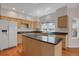 Bright kitchen with wood floors, an island with black countertops, and modern white appliances at 13950 E Chenango Dr, Aurora, CO 80015