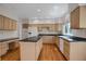 Well-lit kitchen featuring ample cabinetry, a center island, and modern appliances at 13950 E Chenango Dr, Aurora, CO 80015