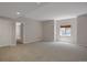 Bright living room boasts neutral carpet, white walls, and a window for natural light at 13950 E Chenango Dr, Aurora, CO 80015