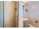 Close up view of a shower with a marble sink and green cabinets at 2525 S Ivanhoe Pl, Denver, CO 80222
