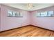 A bedroom with two windows, a ceiling fan, and wood floor at 2525 S Ivanhoe Pl, Denver, CO 80222