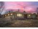 Charming brick home with large windows and attached garage under a vibrant pink sunset at 2525 S Ivanhoe Pl, Denver, CO 80222