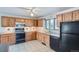Functional kitchen with light wood cabinets, black appliances and white tile flooring at 2525 S Ivanhoe Pl, Denver, CO 80222