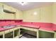 Retro kitchen with vintage yellow cabinets and pink countertops, offering a unique design ready for renovation at 2525 S Ivanhoe Pl, Denver, CO 80222