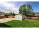 The well-maintained backyard includes a storage shed, lush green grass, and a wooden fence at 11883 W Marlowe Pl, Morrison, CO 80465