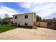A spacious backyard featuring a patio area, lush green grass, and a white two-story house at 11883 W Marlowe Pl, Morrison, CO 80465