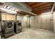 Unfinished basement features a modern washer and dryer, concrete walls and floors, and exposed duct work at 11883 W Marlowe Pl, Morrison, CO 80465
