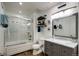 Bright bathroom features a shower-tub, a gray vanity with marble top, and coastal-themed decor at 11883 W Marlowe Pl, Morrison, CO 80465
