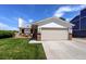 Charming home showcasing a large garage, a well-maintained lawn, and a cozy front porch at 11883 W Marlowe Pl, Morrison, CO 80465