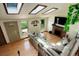 Bright living room showcasing wood floors, fireplace, skylights, a door to the backyard, and a comfortable sectional sofa at 11883 W Marlowe Pl, Morrison, CO 80465