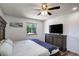 Comfortable main bedroom featuring an entertainment center, wood floors, a large bed, and bright windows at 11883 W Marlowe Pl, Morrison, CO 80465