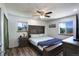 Main bedroom features a comfortable bed, wood floors, two windows with great outdoor views, and a ceiling fan at 11883 W Marlowe Pl, Morrison, CO 80465