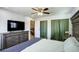 Spacious main bedroom features a ceiling fan, wood floors, a large bed, dresser, and closet with green curtains at 11883 W Marlowe Pl, Morrison, CO 80465