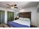 Bright and airy main bedroom features a ceiling fan, wood floors, and a large bed, creating a relaxing retreat at 11883 W Marlowe Pl, Morrison, CO 80465