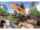 Back patio featuring a table with an umbrella, ideal for outdoor dining at 11883 W Marlowe Pl, Morrison, CO 80465