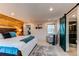 Bright main bedroom featuring wooden accent wall, with ensuite bathroom and barn door entrance at 2823 S Xanadu Way, Aurora, CO 80014