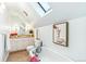 Updated bathroom featuring a skylight, tub, and fun giraffe wall art at 3513 Quitman St, Denver, CO 80212