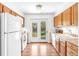 Bright kitchen features wood cabinets, white appliances, and a door leading to the backyard at 3513 Quitman St, Denver, CO 80212