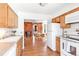 Kitchen features white appliances and a view to the dining area with a brick wall accent at 3513 Quitman St, Denver, CO 80212