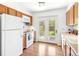 Cozy kitchen with wooden cabinets, white appliances, and a view to the outside at 3513 Quitman St, Denver, CO 80212