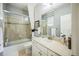 Bright bathroom featuring a tub with glass doors, a toilet, and a vanity with a cream countertop and white cabinets at 1261 W 170Th Ave, Broomfield, CO 80023