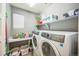 Functional laundry room featuring a side-by-side washer and dryer, a shelf, and storage baskets at 1261 W 170Th Ave, Broomfield, CO 80023