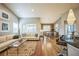 Spacious living room featuring hardwood floors, a comfortable white couch, large windows, and adjacent dining area at 1261 W 170Th Ave, Broomfield, CO 80023