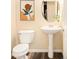Well-lit powder room featuring a pedestal sink, modern fixtures, and decorative wall art at 5562 W 72Nd Pl, Westminster, CO 80003