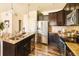 Modern kitchen featuring a granite island, stainless appliances, and dark wood cabinets at 5562 W 72Nd Pl, Westminster, CO 80003