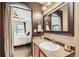 Well-lit bathroom featuring a stylish mirror, sink, and warm color palette at 3668 Pecos Trl, Castle Rock, CO 80109