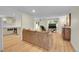 Bright living room featuring hardwood floors, a comfortable couch, and a view of the kitchen at 2840 S Kenton Ct, Aurora, CO 80014