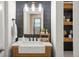 Stylish bathroom featuring modern fixtures, wooden vanity, and decorative mirror at 15960 W 62Nd Dr, Arvada, CO 80403